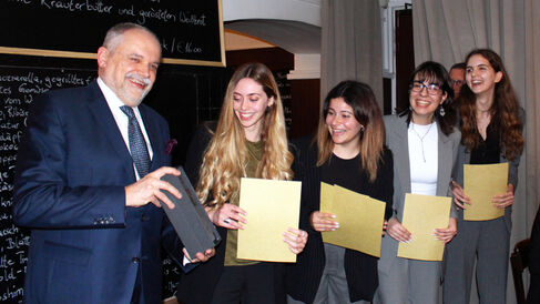 Photograph of the host presenting first prize to the winning Athenian team