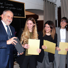 Photograph of the host presenting first prize to the winning Athenian team